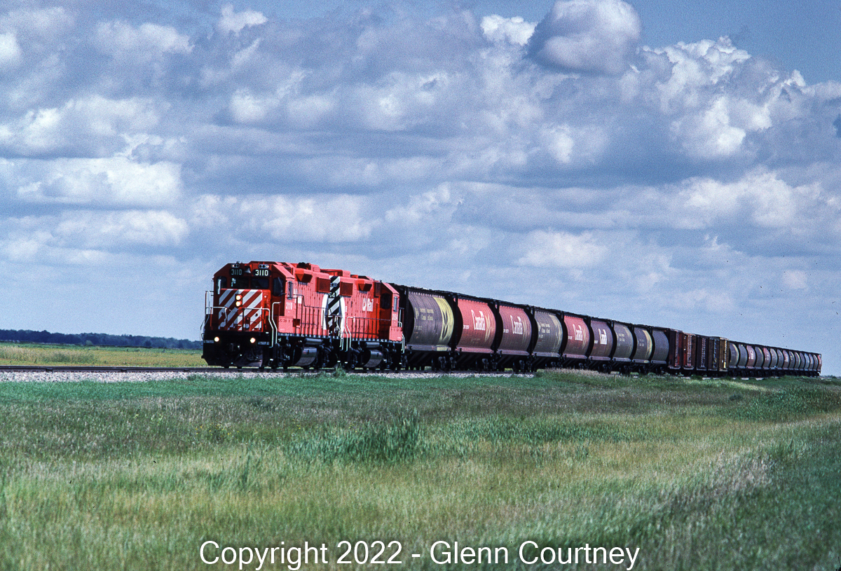 A pair of clean CP Rail GP38-2s head west on the Glenboro Sub with grain hoppers and a few boxcars. We chased this train as far west as Elm Creek to a large Cargill facility which is as far as they went on this trip. It wasn't GP9s and there weren't many traditional wooden grain elevators on the line but it was still a neat way to spend an afternoon.