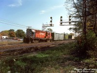 After making its way down the Owen Sound and Orangeville Subdivisions southbound (and <a href=http://www.railpictures.ca/?attachment_id=47463><b>switching the interchange track at Brampton</b></a> enroute), "The Moonlight" has arrived at Streetsville Junction. CP RS18 8751 switches some cars at the south end of the yard, likely taking care of any duties at Streetsville before heading east on the Galt Sub for Toronto. 
<br><br>
<i>Roger Heed photo, Dan Dell'Unto collection slide.</i>