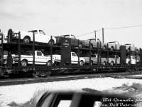 Back when vehicle loads were still visible to trackside bystanders: nearly new CPI 542032 (an 89' open bilevel autorack built by National Steel Car in 1968, CPI reporting marks meant duties were paid for international (I) service) sits in Canadian Pacific's Agincourt Yard loaded with new GMC pickup trucks, likely from the GM Oshawa plant. A wooden van sits coupled to the other end, possibly meaning this was a local or pickup job that recently arrived in the yard off CP's Belleville Sub.
<br><br>
<i>Bill Grandin photo, Dan Dell'Unto collection negative.</i>