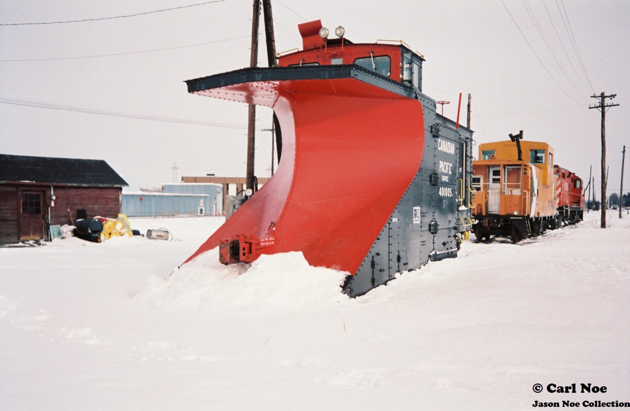 Awaiting it’s next call to duty on Canadian Pacific’s branchlines from Woodstock, CP plow 401005 is viewed at the Woodstock yard along with CP GP9u 8222 and “SOO Only” lettered caboose 434928 during a February winter morning.