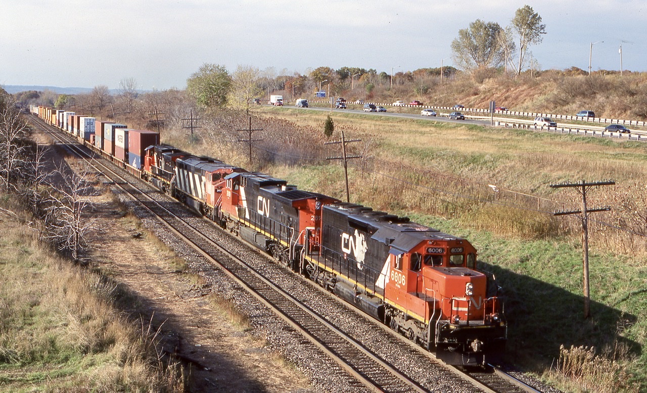 Much of the 2000’s proved to be a rewarding time to be a railfan. A lot of the older power was still kicking around and there was still a lot of variety as far as motive power went, especially on CN.  I quickly took a liking to CN’s rebuilt SD40U’s and tried to catch them when ever I could. While intermodal train 148 was the most reliable eastbound stack train on CN in Southern Ontario, the typically smaller 142 did often make an appearance. In later years it was abolished. It often seemed like 142 simply got the overflow traffic and any extra power needed to be moved back to Toronto. The Concept of the SD40U’s was to take a 1960’s locomotive and rebuild it to last a few more decades, this also included rebuilding the cab and angling the front windows to cut down the sun glare, similar to the GP9RM’s. CN would rebuild less then 30 units before deciding to turn to the second hand market for the rest of its SD40 needs. This day the sun was rapidly loosing against the incoming cloud cover as train 142 rolled through Aldershot with SD40U 6006 in the lead. Today the surviving SD40U’s spend their days deep within CN’s busy yards across the system, their mainline days now in the past.