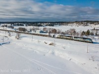 Splitting the signals and splitting waterways, CMQ 9020 East splits the frozen waterways of Lake of the Woods (foreground) and the Winnipeg River (background) as they pass the signals at Keewatin, Ontario with an intriguing visitor trailing... BNSF SD70MAC 9413. Having unloaded rail on the Keewatin, the crew is eastbound approaching Kenora for more paperwork to head out onto the Ignace Sub to dump another string of rail before tying up for the night in the back track at Hawk Lake.