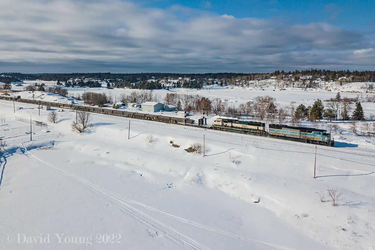 Splitting the signals and splitting waterways, CMQ 9020 East splits the frozen waterways of Lake of the Woods (foreground) and the Winnipeg River (background) as they pass the signals at Keewatin, Ontario with an intriguing visitor trailing... BNSF SD70MAC 9413. Having unloaded rail on the Keewatin, the crew is eastbound approaching Kenora for more paperwork to head out onto the Ignace Sub to dump another string of rail before tying up for the night in the back track at Hawk Lake.