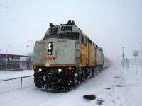 Thick snow is falling as VIA 67 leaves Dorval Station with wrapped VIA 6402 leading.