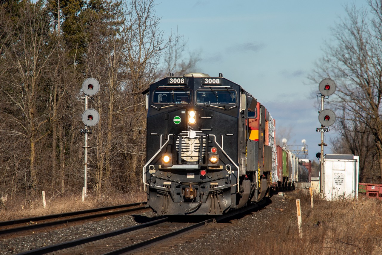As OBRY made one final trip down the CP Owen Sound Sub, CN decided to send a cool CN M397 to distract us from the disappointing day. CN 3008 (Illinois Central "deathstar" paint) and KCSM 4871 haul a good sized train past the searchlights guarding the Stewarttown bridge.

CN 3008 is painted in a replica IC scheme for the 25th anniversary of CN being privately owned (being an IPO). It is one of 6 locomotives in a collection, portraying the companies that CN has absorbed since 1995.

One last note is of the creek. This is the only single track section of the Halton sub between Mile 5 (Humber) and mile 28 (Speyside). I wonder if CN has any plans to double track the bridge over the creek as Stewarttown is known to create bottlenecks. If they do, I'd have to think those gorgeous looking searchlights get replaced.