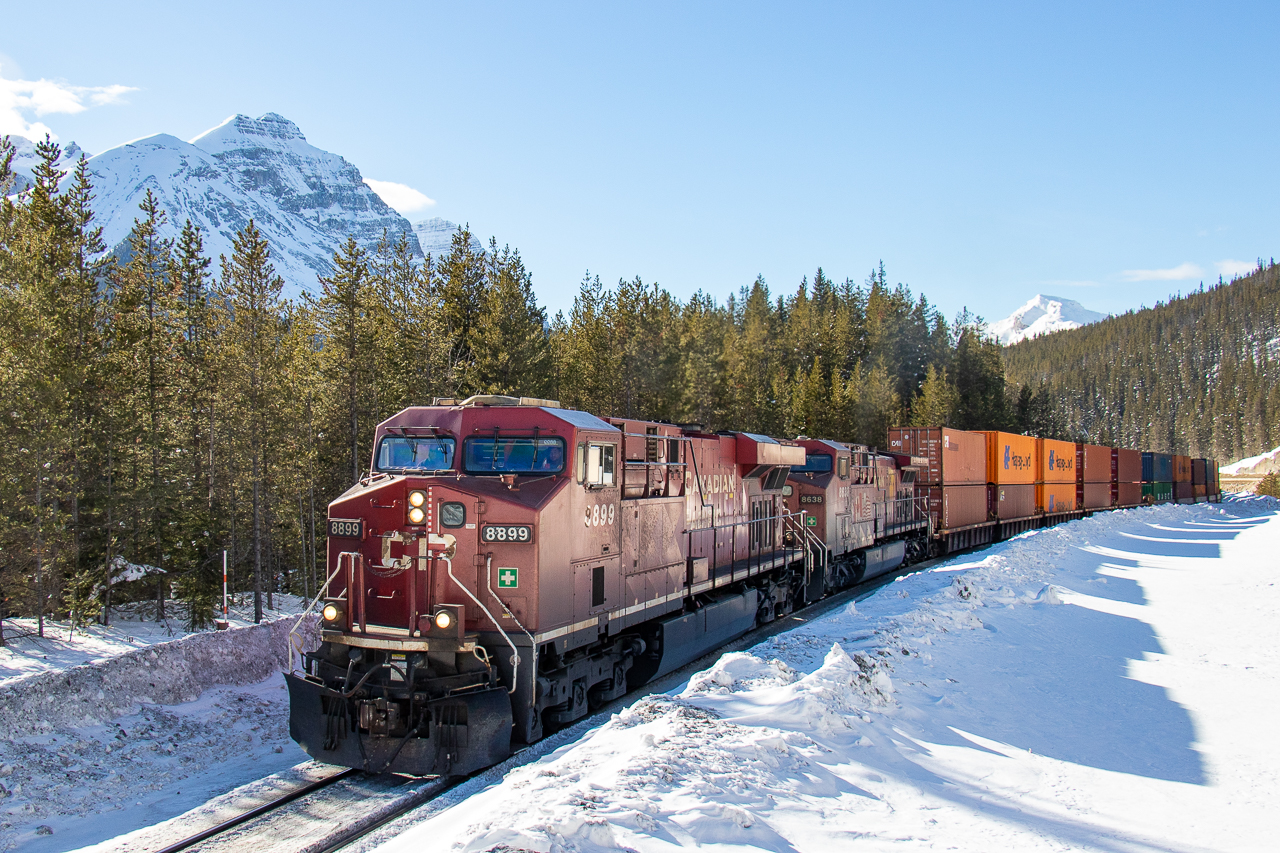 Shortly after leaving Field, 8899 is slowly moving towards Lake Louise with CP 101. Two more westbound trains are waiting just further up past here and will move out after 101 passes. I thought the sunlight reflecting off the snow onto the train gave this an interesting look.