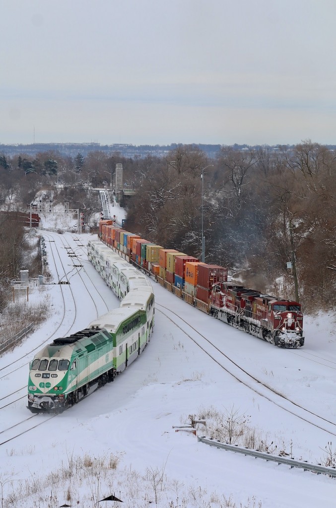 Diverging paths. CP 142 is seen running a lot later than usual as it finally begins the next leg of its journey out of Hamilton with a trio of GP38's pushing hard on its tail end.The Geeps will keep pushing until Waterdown then make their way back to Kinnear yard in Hamilton.  Meanwhile a Hamilton bound GO train passes on CN's Oakville subdivision as it heads for Stuart Street station. I really like this new vantage point at Hamilton West, unfortunately sunny days don't work well here, but that was not an issue today.