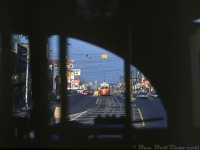 Here's the view riding aboard a TTC PCC streetcar along St. Clair Avenue West one summer morning. Our unknown car is paused to load at Wychwood Avenue before heading westbound on St. Clair and climbing the grade on the approach to the lights at Christie Street. Coming towards us is an eastbound 4500-series A8-Class PCC, seen through the signature right-side arched window of our car. The A8's were the last new TTC PCC's purchased and had symmetrical windows, as opposed to most of the other all-electric PCC's that featured an arched front right window.
<br><br>
<i>Original photographer unknown, Dan Dell'Unto collection slide.</i>