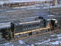 A pair of first generation MLW and GMD switchers shuffle cars around downtown Toronto at Bathurst Street, note the telltails for the bridge.  8138 is seen moving a hopper of coal around the yard leads, perhaps destined for the nearby coaling tower at CN Spadina, while 7030 is moving boxcars about Bathurst Yard.  Note the relatively new yard tower at upper right.  Built in 1949, and originally numbered 7991, the MLW S2 would be renumbered 8138 in 1956.  All of these 1000hp units would be retired by 1975.  The SW1200 7030 in the background was built in 1956 by GMD London, and would be renumbered 7730 in 1985.  She would be retired in August 1990 and sent for scrapping.<br><br><i>Original Photographer Unknown, Jacob Patterson Collection Slide.</i>