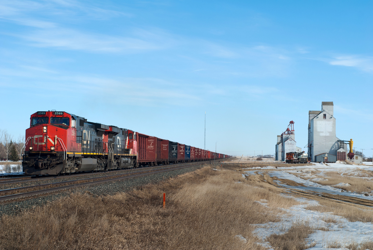 CN 347 has some less than exciting power up front as it passes the row of elevators at Allan Saskatchewan on the Watrous Subdivision.  All three of the elevators in this scene have since been torn down leaving Allan to blend in with so many other indistinct small prairie towns. Gone too, I suppose, is the link to the line's Grand Trunk Pacific heritage as it was a GTP practise to have elevators built so far away from the main.  One only needs to view a few photos of trains passing elevators on the CPR or former CNoR lines to appreciate this.