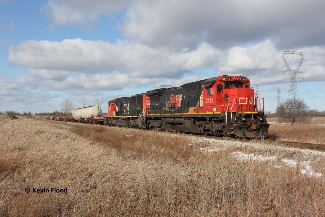 One year ago today, I was out chasing one of the first CN 502s (then CN A402) down the Hagersville Sub, which was also the first time for me shooting a train down the line. It was also convenient being that I was living in the Hamilton area at the time. I got word that the train entered Canada with 4 units, one of them the 2115 and the other one of the CN military units. Based on their positioning, I knew at least one of the two interesting units would be on 502; the other two dropped off in London if I recall correctly. The afternoon was cold and windy with mostly sunny conditions, except after the train was west of Caledonia! The sky became 50/50 with sun and clouds. Luckily though, this train was slow enough that the clouds were not too much of a deterrent. This shot was taken as the train crawled towards its destination of Garnet. Fellow RP.ca contributor Rob Smith and a few others were in on the chase as well.