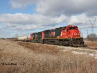One year ago today, I was out chasing one of the first CN 502s (then CN A402) down the Hagersville Sub, which was also the first time for me shooting a train down the line. It was also convenient being that I was living in the Hamilton area at the time. I got word that the train entered Canada with 4 units, one of them the 2115 and the other one of the CN military units. Based on their positioning, I knew at least one of the two interesting units would be on 502; the other two dropped off in London if I recall correctly. The afternoon was cold and windy with mostly sunny conditions, except after the train was west of Caledonia! The sky became 50/50 with sun and clouds. Luckily though, this train was slow enough that the clouds were not too much of a deterrent. This shot was taken as the train crawled towards its destination of Garnet. Fellow RP.ca contributor Rob Smith and a few others were in on the chase as well.