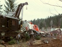 When a broken rail just south of South Wellington derailed Wellcox-to-Victoria train No. 52 on Wednesday 1974-02-20, lead GP9 8531 got across with only its rear truck off, but GP9 8613 in second position was well and truly all off, and idling Baldwin 8005 rolled onto its left side, a major mess which ended its working life.  Auxiliary crane 414326 from Victoria was kept busy, seen here on the initial hoist of 8613, with 8005’s trucks visible just beyond.  This is just a couple miles south of the 1973-06-12 head-on collision which ended the careers of Baldwins 8006, 8007, 8008 and 8011.