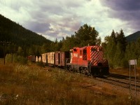 Westward from Cranbrook, CP had a wayfreight to Creston, typically with a single GP9 for power.  Here it is on Saturday 1974-09-28 on its homeward journey with 8494 and a sizeable train at the station name sign for McConnel, 12 miles east of Creston and 55 miles to go, with Mount Thompson standing firmly on guard on the left.