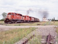 Flipping through the pages of Greg McDonnell’s book “Wheat Kings” I came across a photo from Fleming Saskatchewan in the late 1990’s with a nice large UGG elevator towering over the much smaller rusty, weather beaten Pool elevator. Hard to believe several years later only that lonely forgotten elevator would be the only one left and on Google maps today appears that it may still be there. It was a sad image this day and one found across the prairies of small town once so reliant on their connections to the railroad and their old wooden grain elevators. So many have fallen over the past few decades. Here a SD40, GP38 duo work hard hauling a long empty grain train westward past an elevator the railroad once served. The string of Canadian built cylindrical hoppers only adds to the classic scene, as does the weed choked and severed elevator service track. Things just will never be the same in the prairies without the line side elevators.