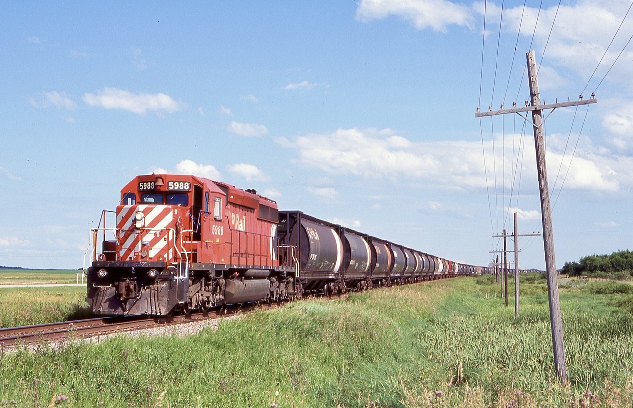 In an image that could also be in the 1980’s, here an empty grain train with a lone multi mark SD40 with almost a full train of Canadian built cylindrical hoppers round the curve at a location I had on the slide as Guiler. Looking now on google maps I can not find the location but it was along the mainline along the Trans Canada highway.
