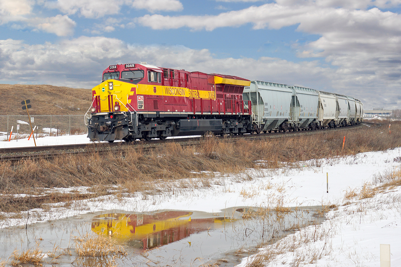 CN 3069 in Wisconsin Central heritag livery heads a frac sand hopper train west through Clover Bar.  Destination will be Sexsmith or Dalehurst.