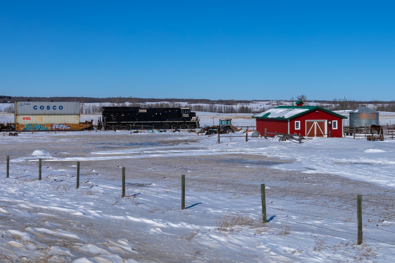 In a scene to be repeated numerous times on its journey across the prairies, Prince Rupert to Montreal Q 18651 08 rumbles past a farm in the frigid breadbasket of Canada.