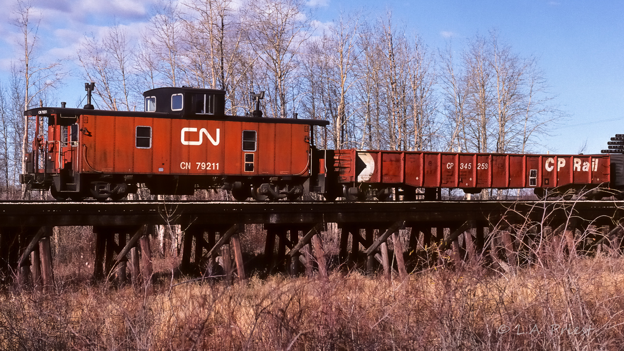 The Thursday at 11:00 836 is on the way east with the 1079, 1069, and 1076 up front, the usual tanks and a few gons at the rear. The clouds played tag with the front of the train. The rear in sunshine, gave an opportunity to photo a random occurrence of CN and CP looking so good together.