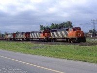 A typical mixed-bag 80's lashup of CN power: CN GP40-2L(W) 9429, SD40 5199, C630M 2031 and HR616 2104 pull freight #431 into Niagara Falls. They appear to be coming off the Stamford Sub onto the Grimsby Sub at Clifton Junction, as seen along Whirlpool Road near Stanley Avenue (on the right, about to cross the tracks).<br><br><i>Reg Button photo, Dan Dell'Unto collection slide.</i>