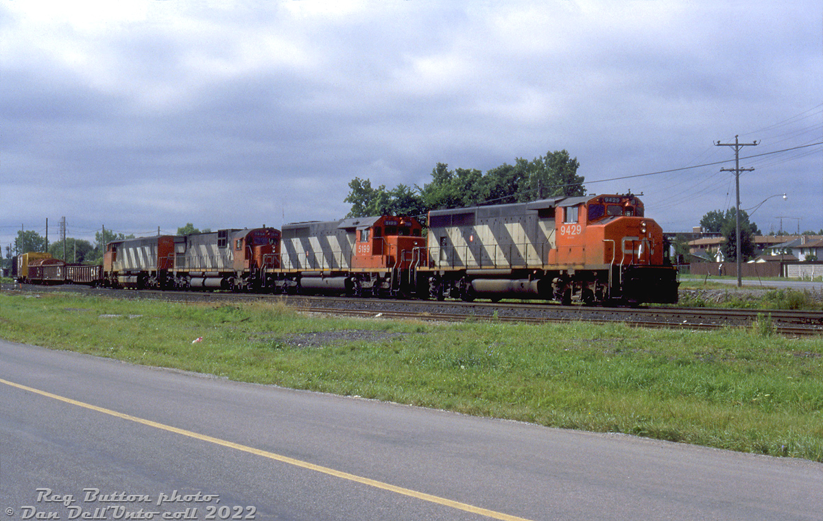 A typical mixed-bag 80's lashup of CN power: CN GP40-2L(W) 9429, SD40 5199, C630M 2031 and HR616 2104 pull freight #431 into Niagara Falls. They appear to be coming off the Stamford Sub onto the Grimsby Sub at Clifton Junction, as seen along Whirlpool Road near Stanley Avenue (on the right, about to cross the tracks).Reg Button photo, Dan Dell'Unto collection slide.