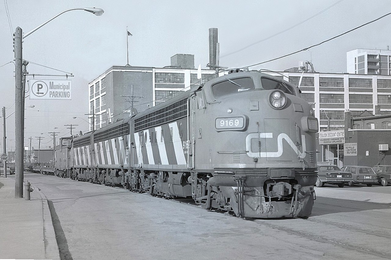 I can't believe it has been more than 9 years since I first posted a colour shot of this train working its' way up Ferguson Ave in downtown Hamilton (#6836).  After the initial shot, I turned and ran along the sidewalk in hopes of getting to my 4x5 Speed Graphic, which was on a tripod waiting. I lined up the shot, popped the cover on the film plate and just barely got this one off. (Didn't have a chance for a slide as well) This looks pretty good.
For me, great memories of that classic A-B-A combination on the Nanticoke steel train #725 while it lasted. In this image is CN 9169, 9196 and 9172.