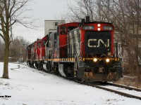 CN L568 has just crossed Queen Street on the Huron Park Spur in Kitchener, Ontario as it heads to the CP interchange to lift a lengthy string of cars. The consist included; 1412, GTW 6226, 4102 and 4138. January 17, 2021.