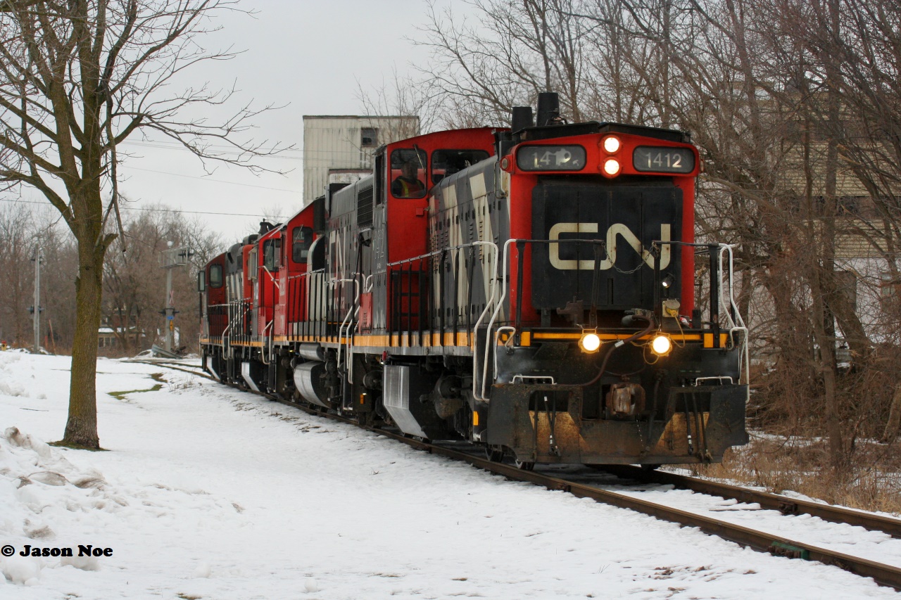 CN L568 has just crossed Queen Street on the Huron Park Spur in Kitchener, Ontario as it heads to the CP interchange to lift a lengthy string of cars. The consist included; 1412, GTW 6226, 4102 and 4138. January 17, 2021.