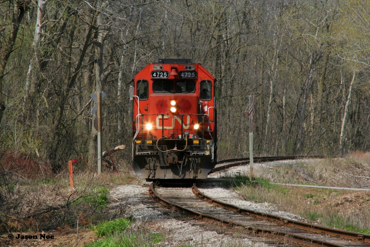 CN GP38-2 4725 solo catches a sunny break as it crosses the pedestrian friendly Iron Horse trail in the heart of Victoria Park in Kitchener as it heads to work the last remaining customer on the Huron Park Spur, which is Ampacet Canada.