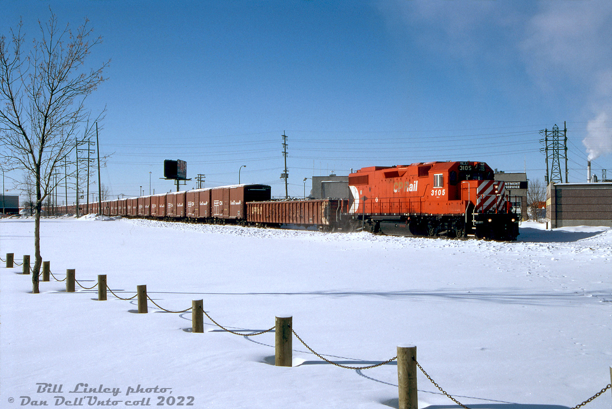 CP GP38-2 3105 has just departed Winnipeg Yard and crossed McPhillips Street crossing, heading up CP's Winnipeg Beach Sub for the trip east out of town for Selkirk, Manitoba. In tow is a single 65' gondola followed by a long cut of CN "Buffalo Boxcars" interchanged to CP, all heading to their final fate at Mandak Metals to be cut up for scrap.  The old 40' boxcar was the standard for transporting grain in Canada for decades until the introduction of covered hoppers, and the build-up of large fleets by CN, CP, and the provincial and federal governments in the 70's and 80's to modernize Canadian grain transportation. Unfortunately, not all branchlines were up to handling those new 100-ton cars, and the aging 40- and 50-ton 40' boxcars, shrinking in number, still soldiered on on many prairie branchlines whose light rail couldn't handle heavier cars. One line in particular that posed a problem was the CN's Hudsons Bay line north to the port of Churchill, Manitoba, that was restricted from using covered hoppers but home to an important government arctic seaport.  Often it was more cost-effective for railways to overhaul the aging boxcars rather than upgrading unprofitable grain-handling branchlines, and governments were willing to invest in new fleets and overhaul programs to help the railways move Canadian grain to market. In the mid-80's, CN undertook a rebuild program using provincial and federal government funds to overhaul a fleet of 40' boxcars for continued service transporting grain to the port in Churchill. Hundreds of these refurbished cars were repainted in a special livery with Canada and Manitoba government lettering (including Manitoba's provincial buffalo logo, hence the nickname). They were restricted from interchange service, and lettered "For Thunder Bay and Churchill grain service only": in the warmer months they shuttled grain from Manitoba and parts of Saskatchewan up the Hudson Bay line to the port in Churchill, and in the colder months when that port was closed, they headed east to the lakehead elevators in Thunder Bay.  It's interesting to note they were all rebuilt with new 8' doors, but kept their old 6' door openings behind them (likely to accept standard grain doors that were sized to fit 6' doorways).  Dwindling fleets of 40' boxcars continued to haul grain for CN and CP into the 90's, but quickly shrinking in number due to age and as prairie branchlines were either upgraded or outright abandoned. Prior to the takeover by Omnitrax, CN lifted the ban on covered hoppers on the line to Churchill in late 1996, and that spelt the end of the Buffalo Boxcar fleet, and the final end to hauling grain in 40' boxcars in Canada. Many were rounded up and sent to Mandak Metals in Selkirk MB for scrapping, where the cut following CP 3105 will ultimately end up.  Bill Linley photo, Dan Dell'Unto collection slide.