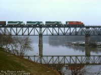 More passenger units hauling freight: CP SD40-2 5738 leads GO Transit GP40-2W's 709, 705, and GP40-3 723 on train #904, eastbound on the Galt Sub crossing the Grand River bridge at Mile 57.44. CP often borrowed the GO commuter units to haul freight (mostly on weekends, and February 18th was a Saturday) in the Windsor-Montreal corridor, and had to have them back to GO in Toronto for Monday morning commuter duties.<br><br>Steve Danko also caught the same train earlier that day at <a href=http://www.railpictures.ca/?attachment_id=47783><b>Coakley (Woodstock)</b></a>.<br><br><i>Reg Button photo, Dan Dell'Unto collection slide.</i>