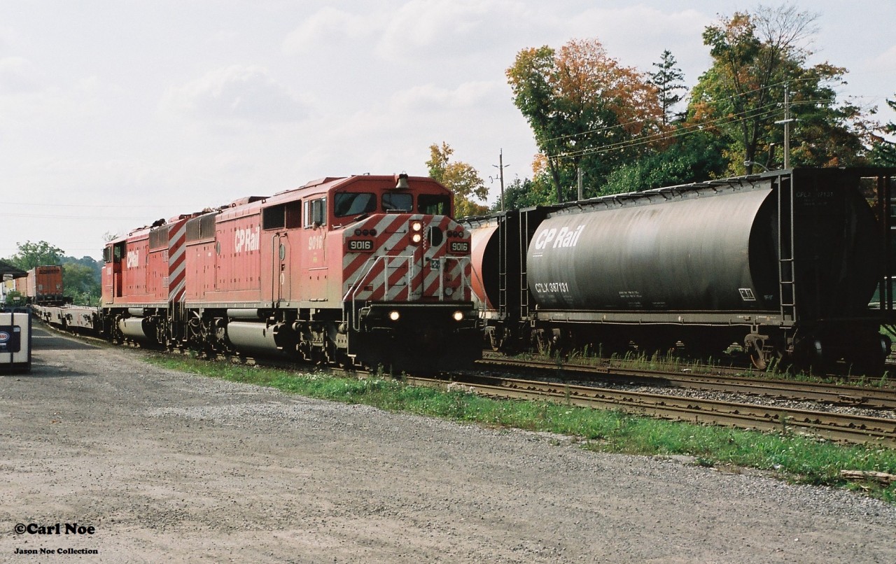 A loaded Expressway train heads eastbound through Galt, Ontario passing the CP depot, powered by a pair of red barn SD40-2F’s during fall 2001.