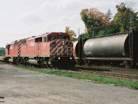A loaded Expressway train heads eastbound through Galt, Ontario passing the CP depot, powered by a pair of red barn SD40-2F’s during fall 2001. 
