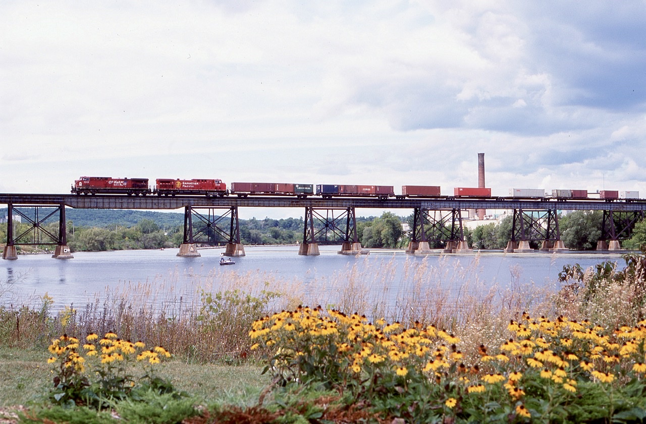 Trenton, Ontario has a fair bit of railroad history to it, and other then the two CN and CP mainlines running through town, CN also had branchlines running both north and south of town. Sadly both branchlines are now history other around a mile of track used to serve one elevator near highway 401. The southern  branchline  extended to Picton and even had a couple swing bridges as well as road running in Trenton. A tourist railway did try to take over the skyline but unfortunately never got things going. Today the line is a rail trail. As for the CP main it crosses the Trent River on an impressive bridge in town, and this day train 241 has a pair of AC4400’s and container traffic stretch over the bridge as it heads westward.