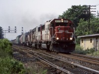 The sun is slowly breaking through the cloud cover as a trip of SOO Line SD60’s pass the old station location in Streetsville. The old brick station was torn down decades ago and replaced by the metal sided structures, which themselves in more recent years were removed as well. A long cut of ballast cars can be seen further back in the train. I miss the SOO units these days. 