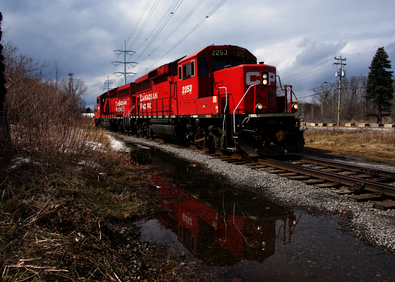 Consecutively numbered GP20C-ECOs (CP 2252 & CP 2253) are reflected in some water as CP F95 heads towards Fleischmann's off the CP Lasalle Loop Spur to lift empties.