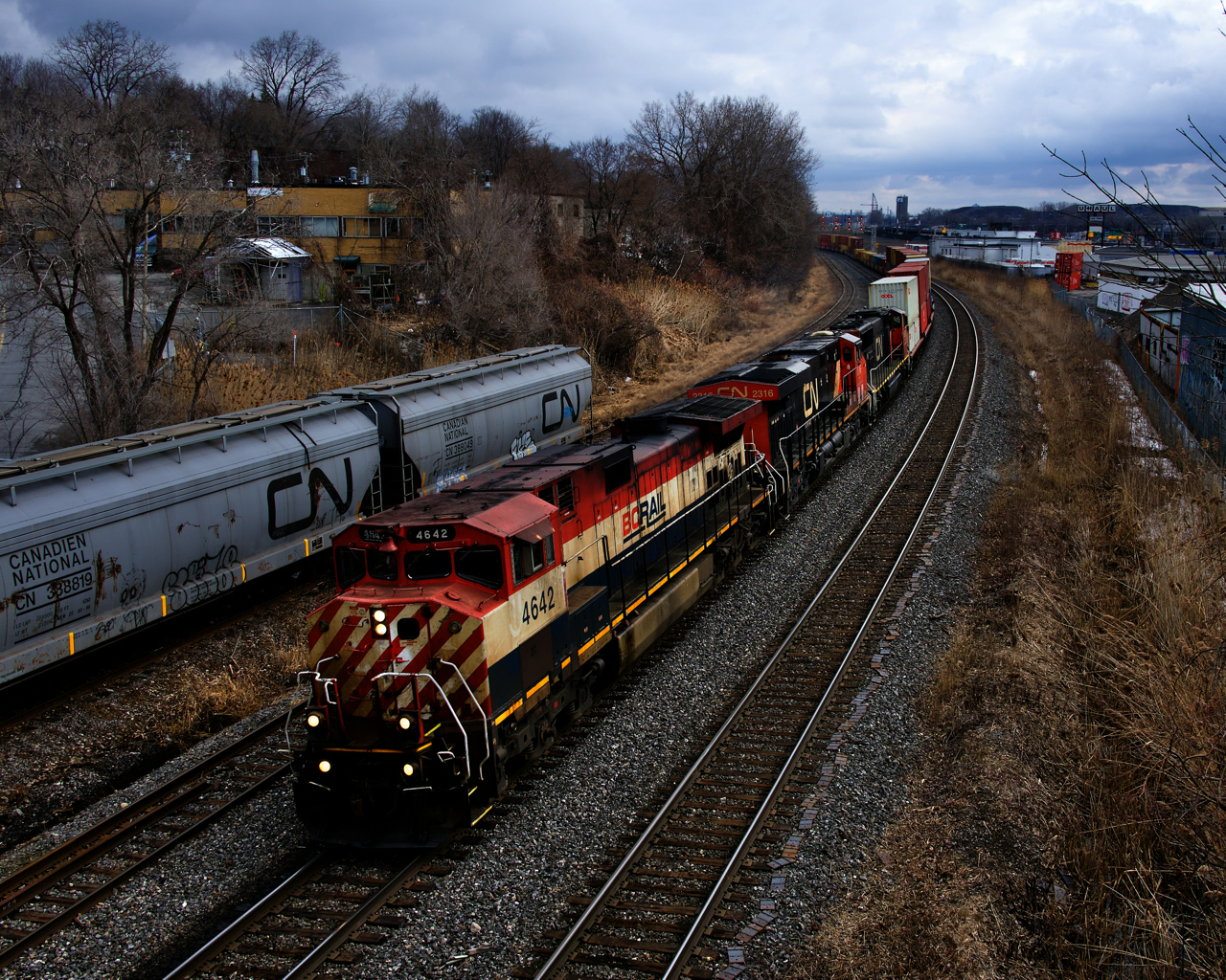 The last red, white and blue Dash9 (BCOL 4642) is leading CN 149 as it passes parked grain cars in Montreal West. Trailing are CN 2316 & CN 5693.