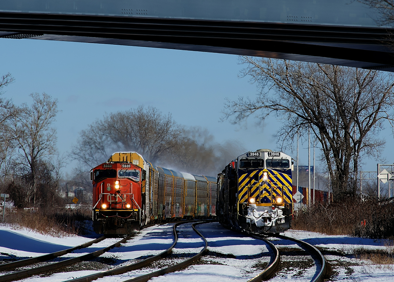 Both CN 271 (at left with class leader CN 5600 leading) and CN 305 (at right with CN 3946 leading) have clear signals ahead as they head west through Dorval side by side.