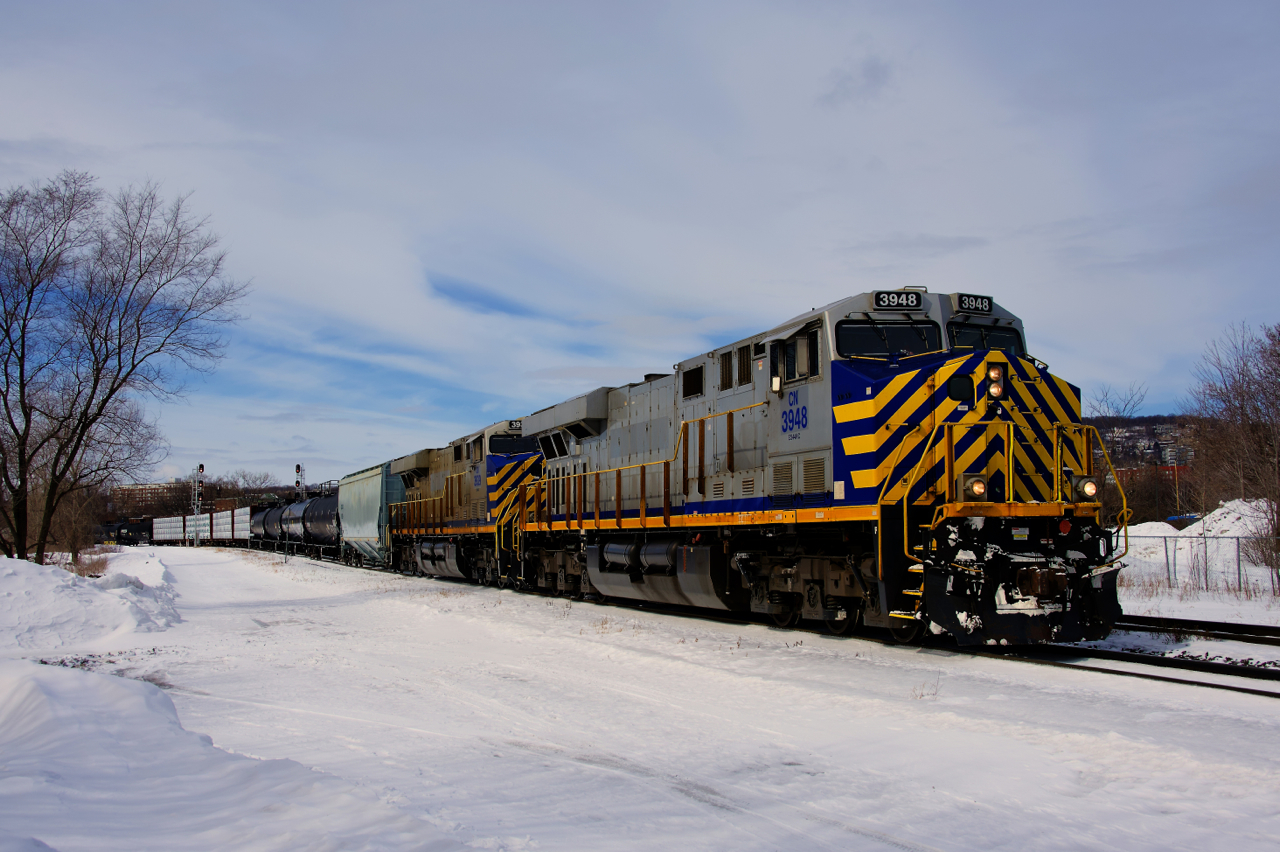 CN 322 has a pair of ex-CREX units arranged elephant style (CN 3948 & CN 3939) as it passes through the St-Henri neighbourhood of Montreal with 112 cars and CN 2802 mid-train.