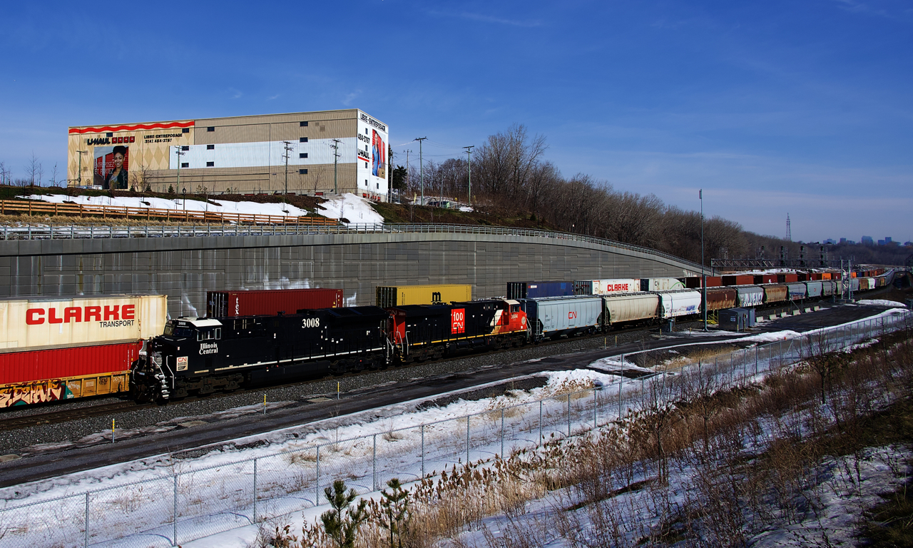 Heritage unit CN 3008 and CN 100 unit CN 3884 are the power on empty grain train CN 875, which has just departed Turcot Ouest after getting recrewed. Behind it CN 120 heads east.