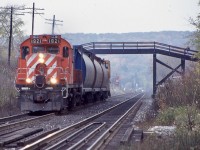 Alway a nice local to chase, the Streetsville turn was typically a Monday to Friday job assigned to Guelph junction. It was a last chance for me, along with the “Ham turn” to photograph the surviving MLW’s in service, not to mention a CP van in the consist. I’m not sure if the wye in streetsville was still intact and usable by this date as sometimes the power would return long hood forward. This day the autumn colours were muted out by the overcast sky as the Streetsville job returns back to Guelph junction with three grain cars out of Reid’s or ADM in Streetsville in tow and a van, as they duck under the wooden farm bridge east of Campbellville. 