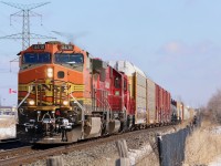 Foreign leaders on westbounds out of Toronto certainly are not as common as on eastbounds. It was nice having the cloud cover clear just before 141 arrived with BNSF Dash-9 4418 in the lead. trailing is a former SOO SD60 and a CP GP38, while an AC4400 is hiding mid train as DPU. Not sure why local T14 ran the north track to Hornby this morning only to be forced to sit it out at Hornby west for a half an hour to wait for 141 to finally pass on the south, then T14 finally got the light to back into Hornby yard. Here 141 is seen leaving Lisgar in the distance , while  Canadian flag flaps in the wind at a local plaza.