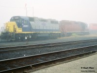 During a very foggy morning, RaiLinK 2001 and 2002 share a shop track at North Bay, Ontario. Notes indicate that OVR train 917 was also there with CP 6037 and HATX 751. As well as RaiLink 4203. 

