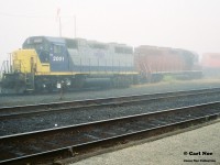 During a very foggy morning, RaiLinK 2001 and 2002 share a shop track at North Bay, Ontario. Notes indicate that OVR train 917 was also there with CP 6037 and HATX 751. As well as RaiLink 4203. 

