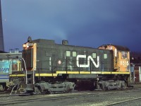 <br>
<br>
   A ' Workhorse ' of the Spadina coach and freight house yards .....in the 'shadow' of the CN Tower – completed 1976,
   <br>
<br>
   MLW 1959 built S-13 CN #8515 and an ex CN Budd Car 
  <br>
<br>
   At CN Spadina, December 15, 1984 Kodachrome by S.Danko  
<br>
<br>
   Most of the S-13 retired by 1990, about eleven rebuilt renumbered to the 8700 series and by 1997 sold to various short lines.


