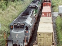Credit at the east end of Georgetown was often an interesting place to take in some train action. Back when the bridge over the Credit River was still single track, a little congestion could really tie up the railroad. Unfortunately Metrolinx push for regular GO service to Kitchener and now Stratford would force CN to finally double track the bridge and for the most part any chance of photographing train meets. A new signal bridge here has also wrecked most westbound shots from the road bridge. On this warm August 2004 day CN train 338 is force to wait at the west side of the bridge while train 393 with a former Alstom SD40 and 2 BNSF SD40’s roll westward past train 338. 