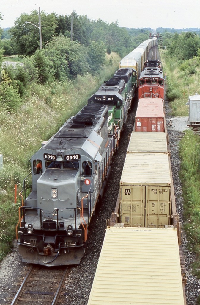 Credit at the east end of Georgetown was often an interesting place to take in some train action. Back when the bridge over the Credit River was still single track, a little congestion could really tie up the railroad. Unfortunately Metrolinx push for regular GO service to Kitchener and now Stratford would force CN to finally double track the bridge and for the most part any chance of photographing train meets. A new signal bridge here has also wrecked most westbound shots from the road bridge. On this warm August 2004 day CN train 338 is force to wait at the west side of the bridge while train 393 with a former Alstom SD40 and 2 BNSF SD40’s roll westward past train 338.