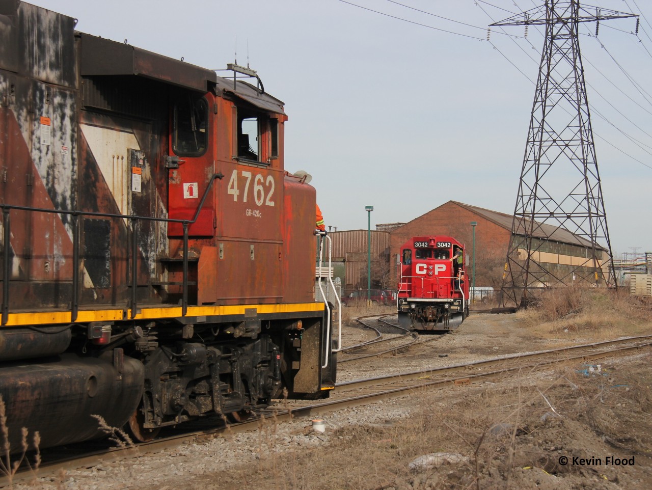 The CN and CP north end Hamilton industrial jobs meet just east of the Ottawa St. crossing on a spring late afternoon just over a year ago. The crew members on both trains give each other some friendly greetings, as the CP job pauses to let the CN job go through.