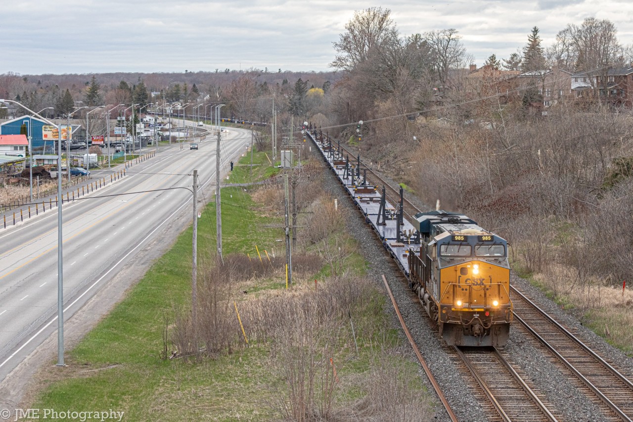 CN X388 is highballing through the outskirts of Kingston following Bath Rd. Upfront is CSXT 985 solo hauling 72 empty windmill blade cars, bound for Gaspe QC.