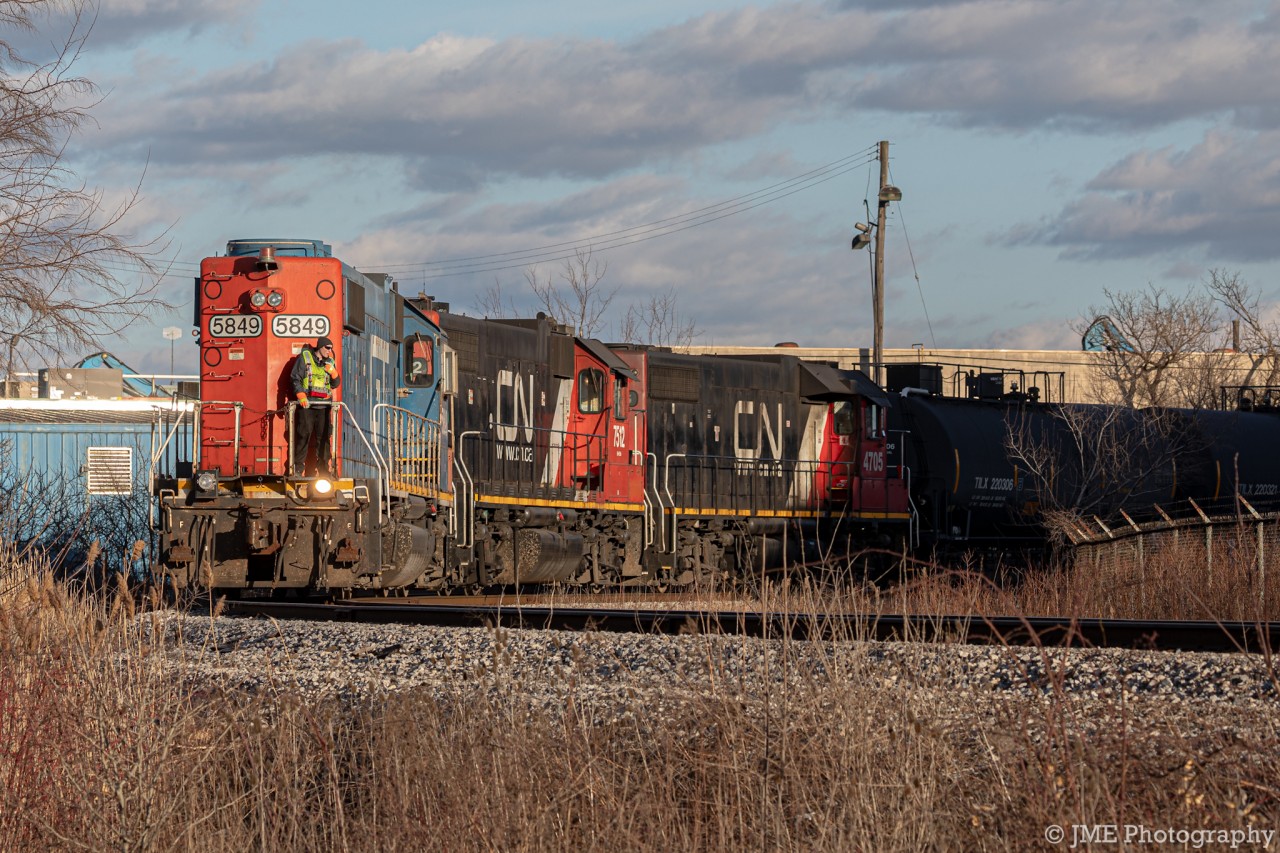 The CN 1600 Job backs up on to the tracks leading up to many of Hamiltons finest industries, by the Hamilton Port. Seen leading Long Hood Forward is GTW 5849 being operated by Beltpack, meaning there’s a remote control strapped to the conductors waist, and he can control the movement of the train, and the horn and bell etc.